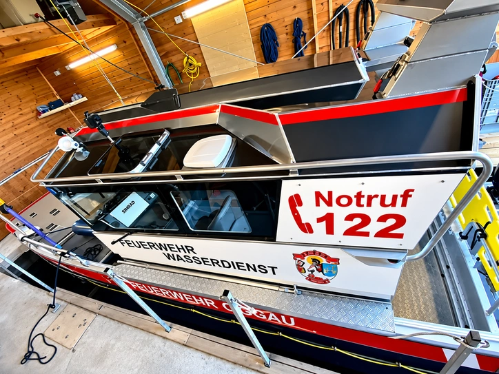 Feuerwehr-Einsatzboot mit professioneller Beschriftung, Notruf 122, Wappen und Wasserdienst-Schriftzug.