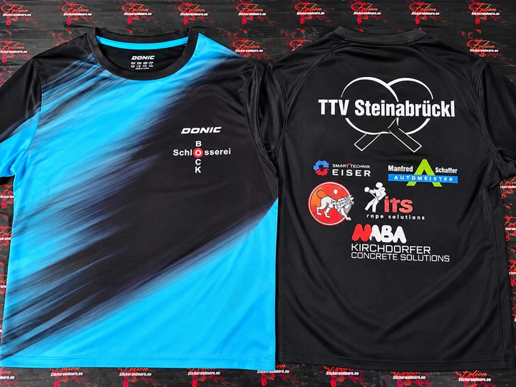 Schwarz-blaue Sportshirts mit Vereinsnamen, Logos und Sponsorendruck auf Vorder- und Rückseite.